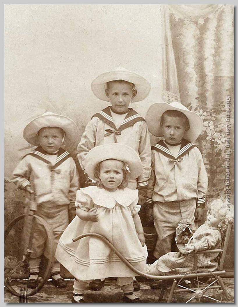 drie jongens in matrozenpakjes en meisje met poppenwagen