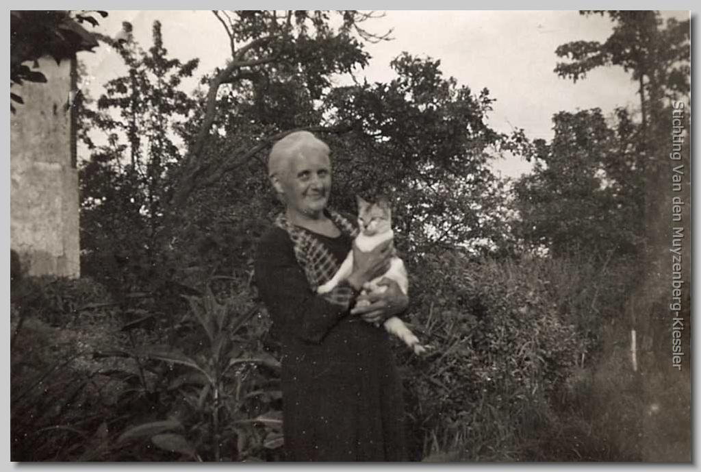 Een dame  in een tuin met de poes op de arm