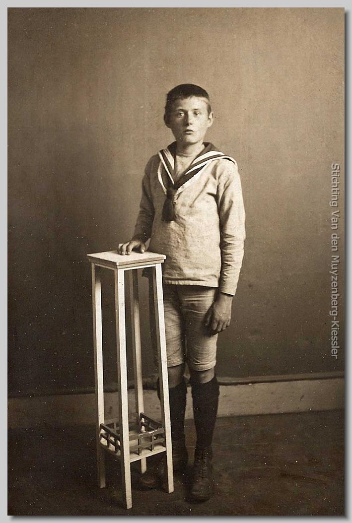 Jongen met padvinderssjaal naast een hoog tafeltje