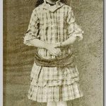 jong meisje met jurk in etages en kleine laarsjes