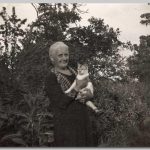 Een dame  in een tuin met de poes op de arm