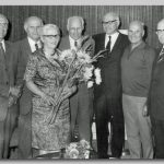 Broers en zuster, 1964 Zes mannen met brillen en één vrouw met een bos bloemen