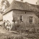 Groep mensen voor de boerderij in een dicht begroeide tijn