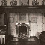 Open haard met tegels er omheen en porselijnen borden er boven