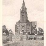 Aleksandrów - Katholieke Kerk alleenstaand kerkje met groot wit hek er omheen