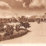 heel groot plein met links een paar bomen en huizen in de verte