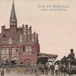 Gebouw met toren, stoomlocomotief en paard en wagens er voor