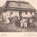 Wit huisje met rieten dak  met vrouw en zeven kinderen er voor