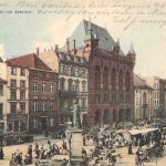 Straat met veel gebouwen er langs en mensen op de straat.