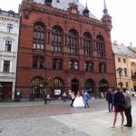 Rood bakstenen gebouw met stel in bruidskleding er voor