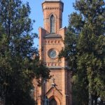 klein kerkje met spitse toren omgeven door bomen