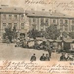 plein met huizen, markt kraampjes en mensen